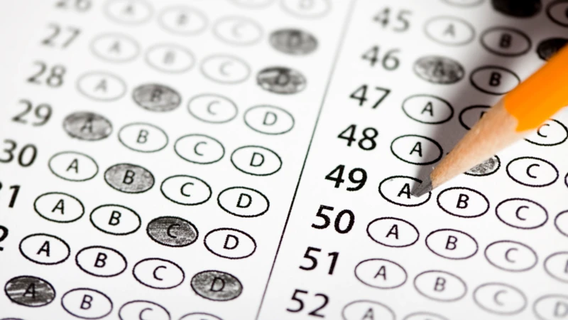 A photo of a test bubble sheet with penciled bubbled filled in and a pencil at the top.