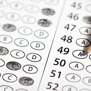 A photo of a test bubble sheet with penciled bubbled filled in and a pencil at the top.