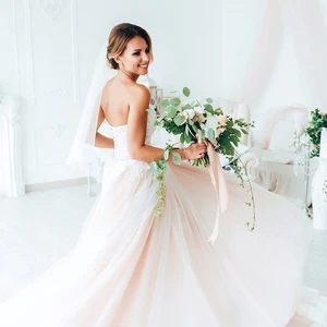 A bride looking over her shoulder with a bouquet in her hand.