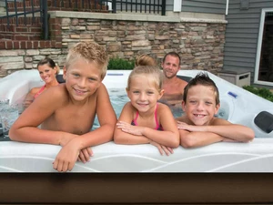 A family of five enjoying their outdoor hot tub. 